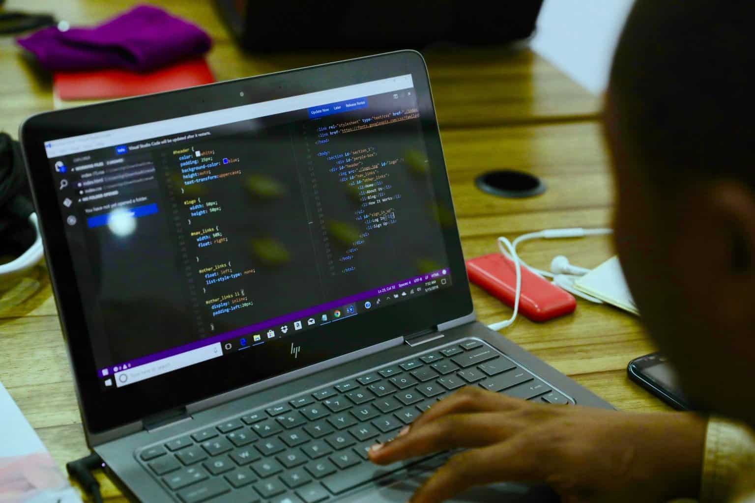 Laptop with Replit open and some Python code written.